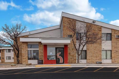 a brick building with a red door on a street at Motel 6-Lakeville, MN - South - Lakeville in Lakeville