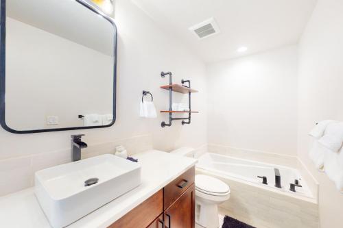 een badkamer met een witte wastafel en een spiegel bij Sleepy Hollow in Donnelly