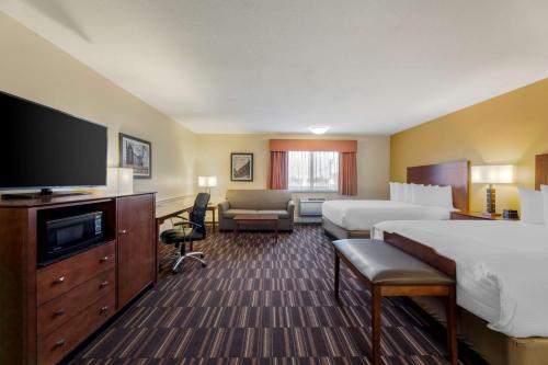 a hotel room with two beds and a flat screen tv at Best Western Falcon Plaza in Bowling Green