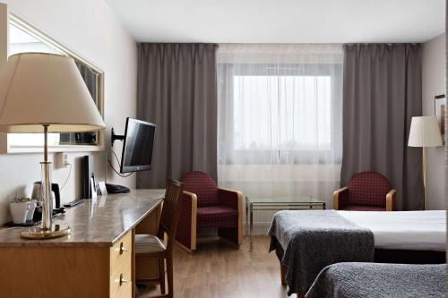 a hotel room with a bed and a desk and chairs at Best Western Gustaf Froding Hotel & Konferens in Karlstad