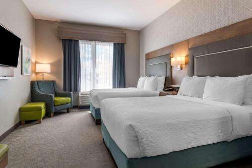 a hotel room with two beds and a chair at Best Western Plus Dartmouth Hotel & Suites in Halifax