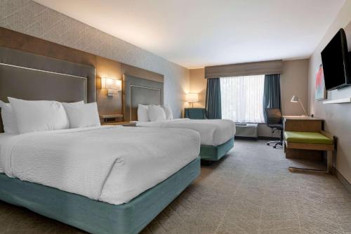 a hotel room with two beds and a television at Best Western Plus Dartmouth Hotel & Suites in Halifax