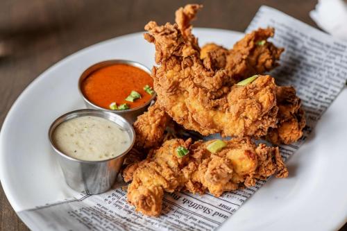 a plate with fried chicken and dipping sauce on it at Best Western Plus Dartmouth Hotel & Suites in Halifax