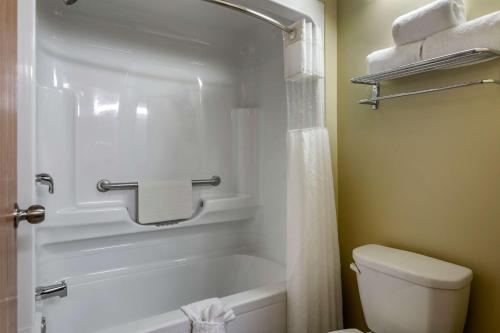 a bathroom with a white tub and a toilet at Best Western Plus Dartmouth Hotel & Suites in Halifax