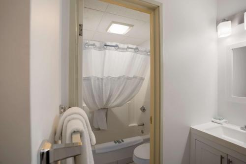 uma casa de banho com um chuveiro, um WC e um lavatório. em SureStay Hotel by Best Western Presque Isle em Presque Isle