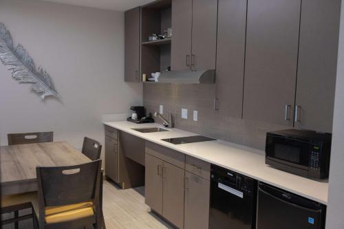 a kitchen with a sink and a microwave at Best Western Plus Executive Residency Phoenix North Happy Valley in Phoenix