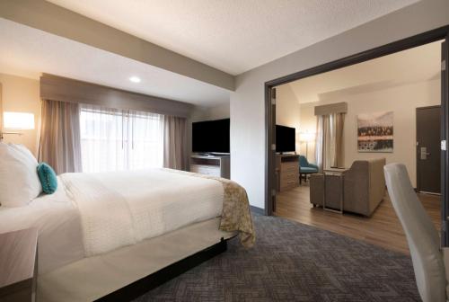 um quarto de hotel com uma cama e uma sala de estar em Best Western Fishkill Inn & Suites em Fishkill