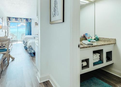 een kamer met een badkamer met een wastafel en een spiegel bij Ocean front comfy condo w/kitchen, sleeps 4, Snowbird Paradise in Myrtle Beach