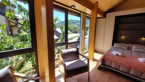1 dormitorio con 1 cama, 1 silla y 1 ventana en Hermoso monoambiente con entrepiso, para 3 personas, excelente ubicación y vista. 23V5 en San Martín de los Andes