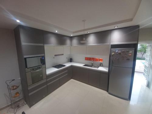 a kitchen with gray cabinets and a stainless steel refrigerator at 1670 House in Mendoza