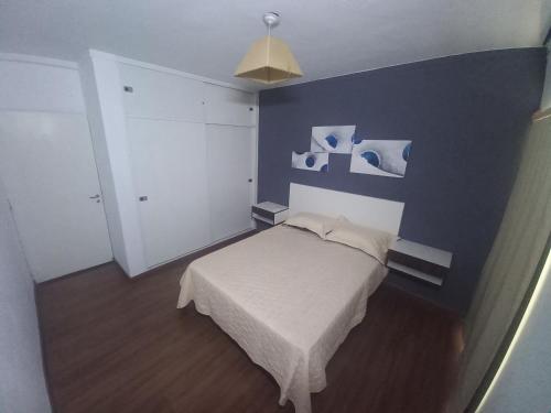 a bedroom with a bed and a blue wall at 1670 House in Mendoza