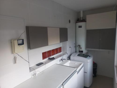 a white kitchen with a sink and a washing machine at 1670 House in Mendoza