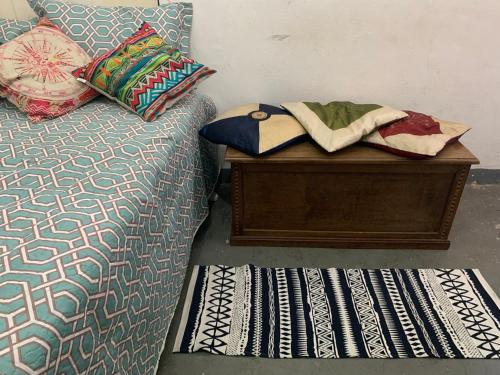 1 dormitorio con cama y mesa con almohadas en Kitnet Centro RJ, en Río de Janeiro
