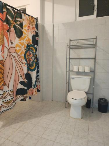 y baño con aseo y cortina de ducha. en Large and comfy apartment, near DT and Principal Beach! en Zihuatanejo