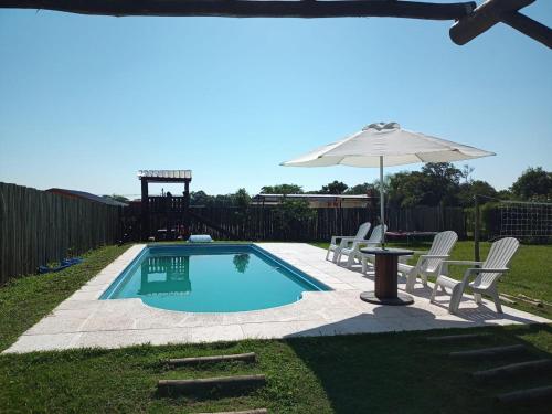 una pequeña piscina con sillas y sombrilla en La Bendición en Campo Quijano