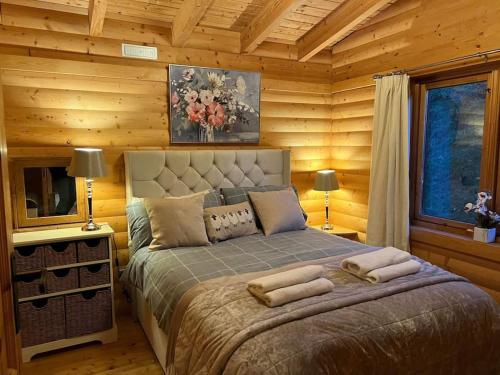 a bedroom with a bed in a log cabin at Riverside Lodge in Killiecrankie in Bridge of Tilt