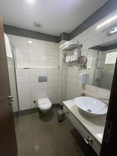 a bathroom with a sink and a toilet at Marrakeschotel in Tuzla