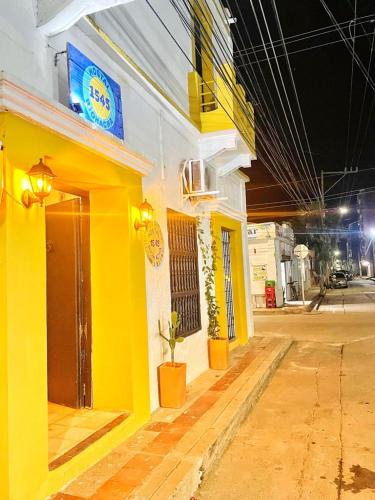 a yellow building with a sign on the side of it at Hostal 1545 in Ríohacha