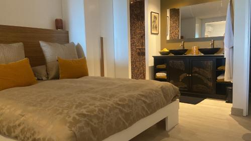 a bedroom with a bed and a vanity with a mirror at Le Rocher in Gustavia
