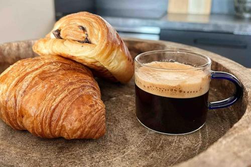 a cup of coffee and two croissants on a plate at L'Imperti'Nantes in Nantes