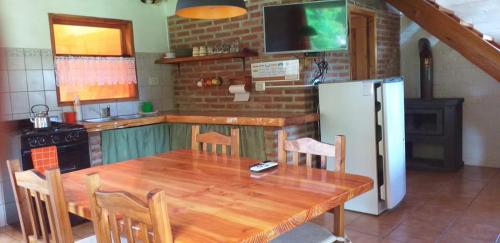 a kitchen with a wooden table and a refrigerator at Cabaña en El Hoyo in El Hoyo