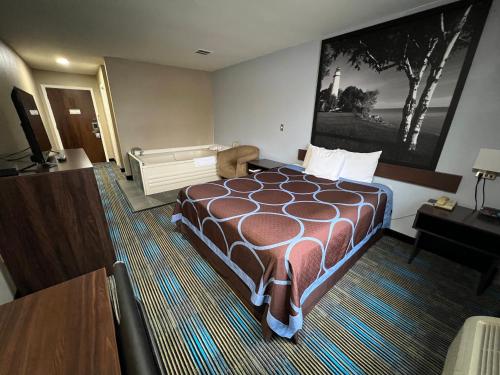 a hotel room with a bed and a piano at Super 8 by Wyndham Escanaba in Escanaba