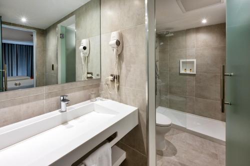 a bathroom with a sink and a toilet and a mirror at W&P Santo Domingo in Santo Domingo