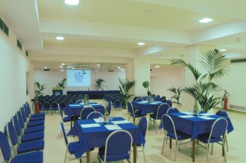 un salón de banquetes con mesas y sillas azules en Reginna Palace Hotel, en Maiori
