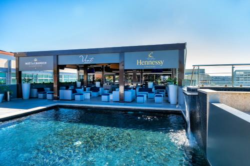 a hotel with a swimming pool in front of a building at W&P Santo Domingo in Santo Domingo