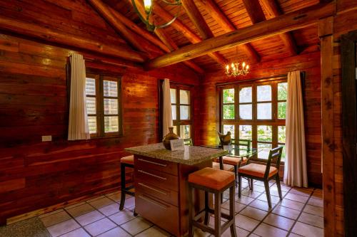 a kitchen in a log cabin with a table and chairs at Santa María Resort in Santa María del Oro