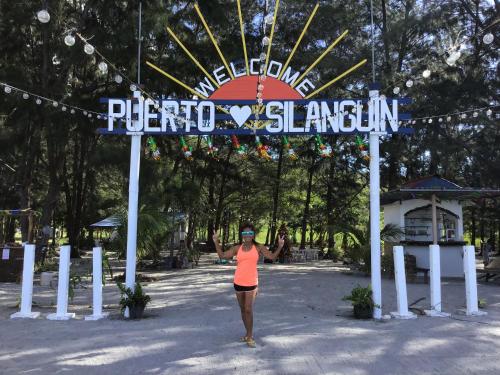 a woman standing under a sign at a park at Puerto Silanguin Beach Camping Resort in Zambales