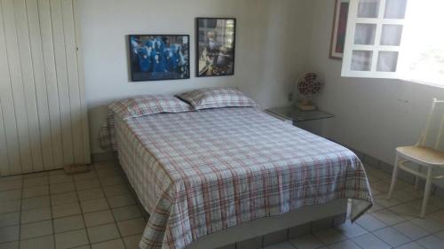 a bedroom with a bed with a plaid blanket at Casa com piscina em Gravatá PE in Gravatá