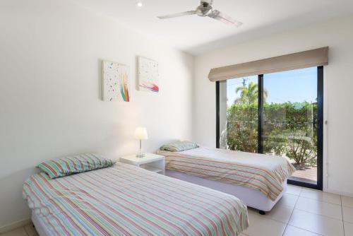 two beds in a room with a window at Rainbow Surf 2 in Rainbow Beach