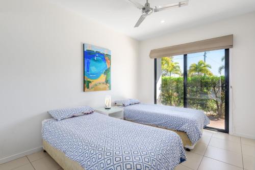 two beds in a room with a window at Rainbow Surf 3 in Rainbow Beach