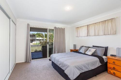a bedroom with a bed and a large window at Rainbow Tides in Rainbow Beach