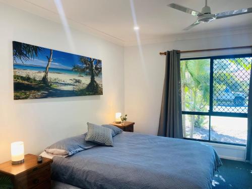 a bedroom with a bed and a large window at Sandys On Cypress in Rainbow Beach