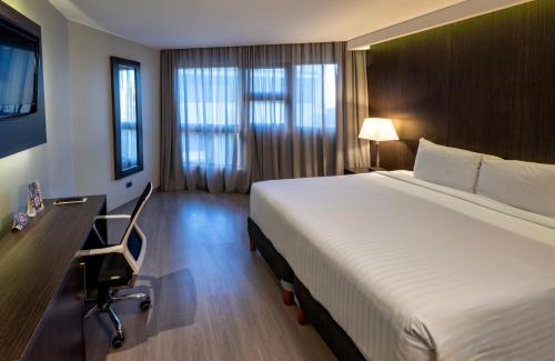 a hotel room with a bed and a desk and a computer at W&P Santo Domingo in Santo Domingo