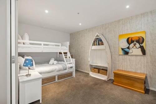 een slaapkamer met 2 stapelbedden en een tafel bij Nautical Beach Vibe - Downtown Mount/Beach in Mount Maunganui