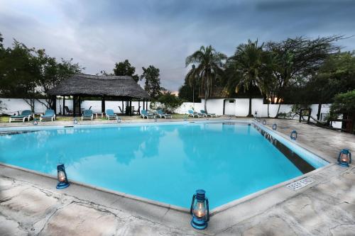 a large blue swimming pool with a gazebo at Mara River Lodge in Aitong