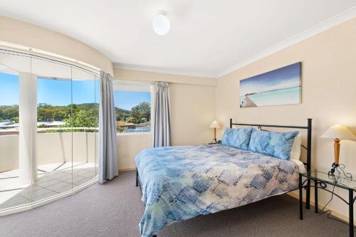 une chambre avec un lit et une grande fenêtre dans l'établissement 11 Seashells, à Nelson Bay