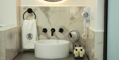 łazienka z białą wanną i suszarką do włosów w obiekcie Hotel Roma 191 w mieście Meksyk