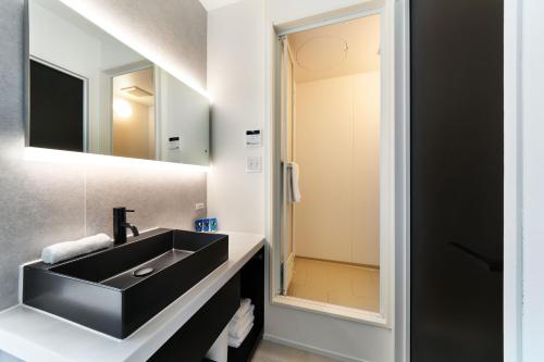 a bathroom with a black sink and a mirror at WHARFandCO in Himi