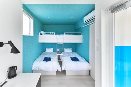 two bunk beds in a room with blue walls at WHARFandCO in Himi