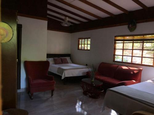 a room with a bed and a bed and a couch at ECO Hostal Monolandia in El Zaino
