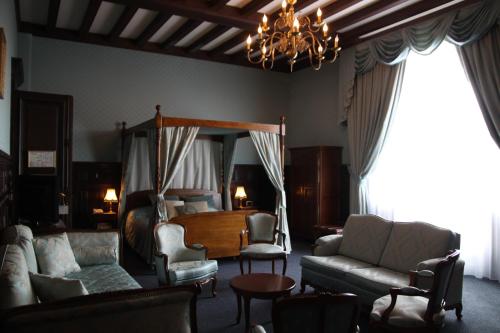 a living room with a bed and a couch and chairs at Château Des Bondons EI in La Ferté-sous-Jouarre