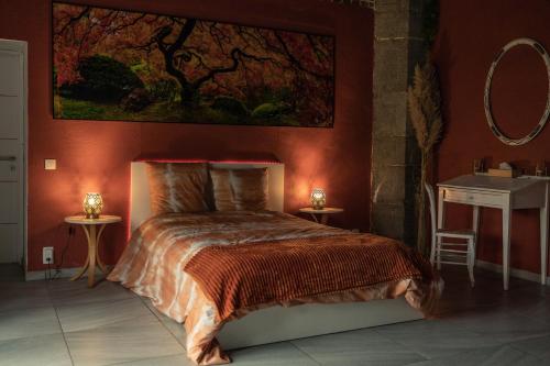 una camera da letto con un letto e un dipinto sul muro di Le Temple d'Opaline a Boneffe