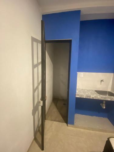een deur naar een kamer met een blauwe muur bij Cuarto Ajalpan 