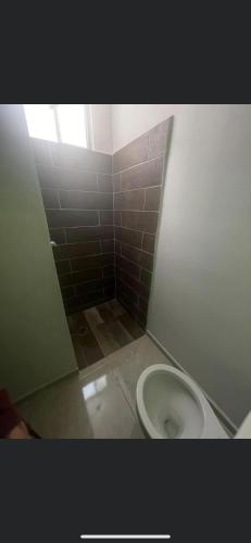 La salle de bains est pourvue de toilettes blanches. dans l'établissement Cuarto Ajalpan, 