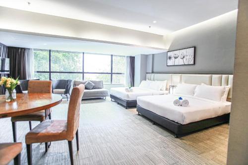 um quarto de hotel com duas camas e uma sala de estar em Fives Hotel DNP em Johor Bahru