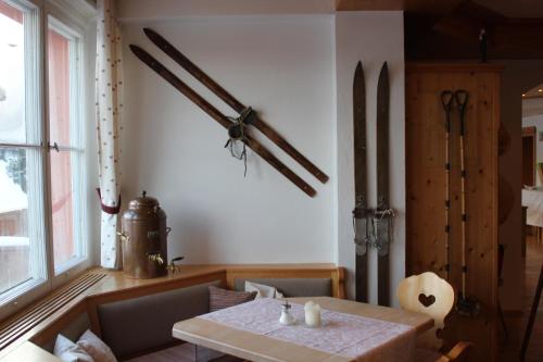 een eetkamer met een tafel en wat wapens aan de muur bij Haus Sommerberg in Feldberg